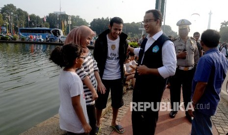 Menteri Pendidikan dan Kebudayaan Anies Baswedan berbincang dengan pengunjung car free day saat sosialisasi kampanye anter anak pada hari pertama sekolah di Patung Kuda, Jakarta, Ahad (17/7). (Republika/Yasin Habibi) 