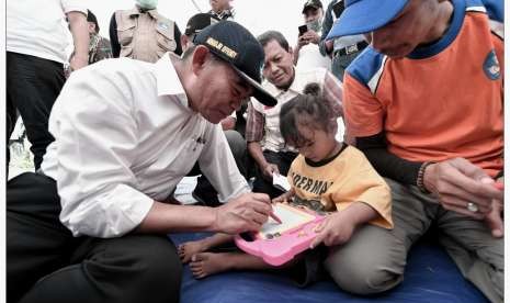 Menteri Pendidikan dan Kebudayaan (Mendikbud) Muhadjir Effendy ketika mengunjungi kelas darurat di camp pengungsian Petobo, Kota Palu.