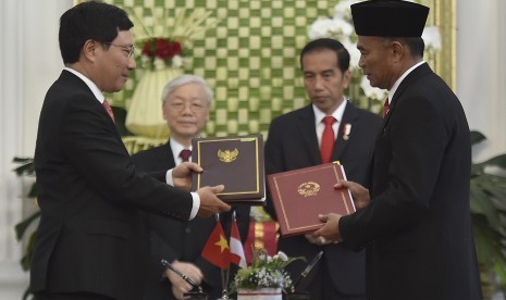 Menteri Pendidikan dan Kebudayaan Muhadjir Effendy (kanan) dan Wakil Perdana Menteri sekaligus Menteri Luar Negeri Vietnam Pham Binh Minh (kiri) bertukar nota kesepakatan kerjasama bidang pendidikan disaksikan oleh Presiden Joko Widodo (kedua kanan) dan Sekretaris Jenderal Partai Komunis Vietnam Nguyen Phu Trong (kedua kiri) di Istana Merdeka, Jakarta, Rabu (23/8).