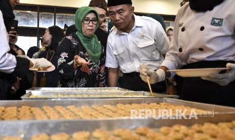 Menteri Pendidikan dan Kebudayaan Muhadjir Effendy (kanan) didampingi Kepala Dinas Pendidikan Provinsi Jawa Barat (kiri) melihat proses pembuatan kue yang dibuat oleh siswa SMKN 9 Bandung saat kunjungan kerja di Kota Bandung, Kamis (21/2).