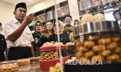 Menteri Pendidikan dan Kebudayaan Muhadjir Effendy (kanan) didampingi Kepala Dinas Pendidikan Provinsi Jawa Barat (kiri) melihat proses pembuatan kue yang dibuat oleh siswa SMKN 9 Bandung saat kunjungan kerja di Kota Bandung. 