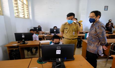 Menteri Pendidikan, Kebudayaan, Riset dan Teknologi (Mendikbudristek), Nadiem Makarim, didampingi Wali Kota Solo, Gibran Rakabuming Raka, saat meninjau pelaksanaan pembelajaran tatap muka (PTM) di SMP Negeri 1 Solo, Senin (13/9)