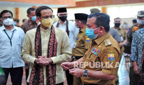 Menteri Pendidikan, Kebudayaan, Riset dan Teknologi Nadiem Makarim (kiri) berbincang dengan Gubernur Jambi Al Haris (kanan) saat meninjau vaksinasi COVID-19 di Makorem 042 Garuda Putih, Jambi, Selasa (21/9/2021). Dalam kunjungan kerja pertamanya ke Provinsi Jambi, Nadiem Makarim selain meninjau vaksinasi, juga dijadwalkan melakukan dialog dengan pimpinan PTN/PTS dan mahasiswa di Universitas Jambi, serta komunitas seniman dan budayawan di sekitar Kawasan Percandian Muarajambi pada Rabu (22/9).