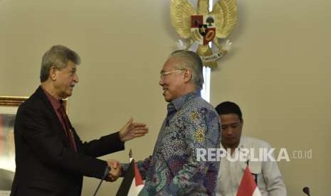 Menteri Perdagangan Enggartiasto Lukita (tengah) berjabat tangan dengan Duta Besar Palestina untuk Indonesia Zuhair Al Shun (kiri) usai penandatanganan Nota Kesepahaman terkait pengaturan bea masuk kurma dan minyak zaitun Palestina ke Indonesia di Jakarta, Senin (6/8).