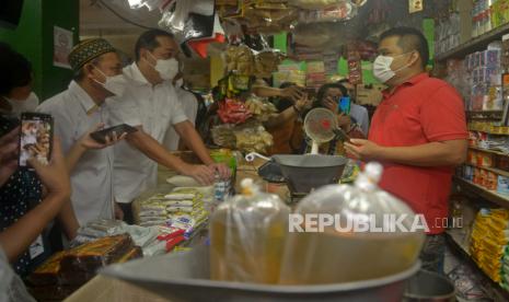 Menteri Perdagangan Muhammad Lutfi berbincang dengan pedagang saat meninjau tempat penjualan Program MigorRakyat di Pasar Kampung Ambon, Pulogadung, Jakarta, Selasa (7/6/2022).  Program MigorRakyat yang memanfaatkan sistem teknologi digital ini bertujuan untuk mengoptimalisasi pendistribusian minyak goreng curah dengan harga sesuai harga eceran tertinggi (HET) yaitu Rp 14.000 sehingga dapat diakses oleh masyarakat.Prayogi/Republika