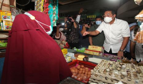 Menteri Perdagangan Muhammad Lutfi (kanan) berbincang dengan pedagang di Pasar Tambahrejo, Surabaya, Jawa Timur, Jumat (18/2/2022). Kunjungan di pasar itu untuk mengetahui secara langsung harga serta ketersediaan sejumlah bahan pangan terutama minyak goreng.