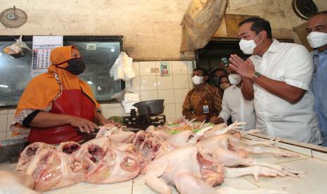 Menteri Perdagangan Muhammad Lutfi (kedua kanan) berbincang dengan pedagang di Pasar Tambahrejo, Surabaya, Jawa Timur, Jumat (18/2/2022). Kunjungan di pasar itu untuk mengetahui secara langsung harga serta ketersediaan sejumlah bahan pangan terutama minyak goreng. 