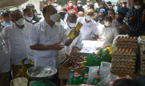 Menteri Perdagangan Muhammad Lutfi (kedua kiri) didampingi Wali Kota Banda Aceh, Aminullah Usman (keempat kanan) mengecek harga dan stok minyak goreng saat sidak di pasar Al Mahirah, Desa Lamdingin, Banda Aceh, Sabtu (26/2/2022). Menteri Perdagangan Muhammad Lutfi menemukan harga minyak goreng kemasan di pasar tersebut masih tinggi mencapai Rp17.500 per liter dan minyak goreng curah Rp14.500 per liter karena stoknya berkurang dan pemerintah akan berupaya mengatasinya dengan memasok minyak goreng dari Medan karena stoknya di daerah itu melimpah.