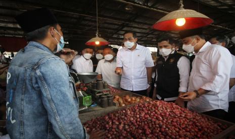 Menteri Perdagangan Muhammad Lutfi (ketiga kanan) didampingi Wakil Gubernur Jawa Timur Emil Elestianto Dardak (kedua kanan) dan Wali Kota Surabaya Eri Cahyadi (kanan) berbincang dengan pedagang bawang merah saat mengunjungi Pasar Induk Osowilangun, Surabaya, Jawa Timur, Selasa (20/4/2021). Kunjungan Menteri Perdagangan tersebut dalam rangka untuk melihat secara langsung ketersediaan stok bahan kebutuhan pokok dan memastikan harga pangan normal. 