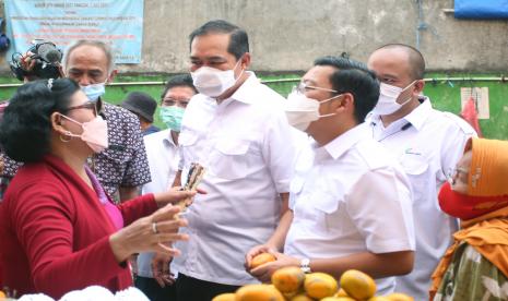 Menteri Perdagangan Muhammad Lutfi (tengah) didampingi Kepala Badan Pangan Nasional Arief Prasetyo Adi (kedua kanan) berbincang dengan warga saat meninjau langsung pendistribusian minyak goreng curah untuk pedagang eceran di Pasar Kebayoran Lama, Jakarta, Rabu (9/3/2022). Kementerian Perdagangan menyatakan stok minyak goreng dan harganya akan terus stabil terlebih menjelang Ramadhan dan Idul Fitri 2022.