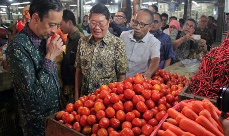 Menteri Perdagangan Thomas Lembong memeriksa kondisi buah tomat yang dijual pedagang saat melakukan kunjungan ke Pasar Induk, Tangerang, Banten, Selasa (10/11)