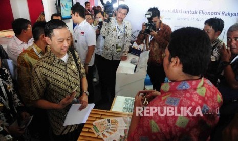  Menteri Perdagangan, Thomas T Lembong (kiri) mendengarkan penjelasan tentang aplikasi pasar tradisional online di stan Bank Mandiri saat peluncuran Sinergi Aksi untuk Ekonomi Rakyat di Desa Larangan, Kecamatan Larangan, Brebes, Jawa Tengah, Senin, (11/4).