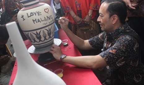 Menteri Perdagangan Thomas Trikasih Lembong melukis di atas keramik saat berkunjung di sentra kerajinan keramik Dinoyo, Malang, Jawa Timur, Jumat (1/4).