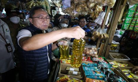 Menteri Perdagangan Zulkifli Hasan menunjukkan minyak goreng saat meninjau bahan pokok dan minyak goreng di Pasar Ciracas, Jakarta, Selasa (5/7/2022). Kunjungan kerja tersebut dilakukan untuk melihat dan memantau langsung harga bahan pokok dan minyak goreng serta titik penjualan minyak goreng curah rakyat (MGCR). 