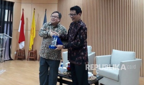  Menteri Perencanaan Pembangunan Nasional/Kepala Bappenas Bambang P. S Brodjonegoro menerima tanda apresiasi dari Kepala Pusat Kegiatan Mahasiswa FEB UI Pribadi Setiyanto usai memberi paparan tentang ekonomi pembangunan Islam di Kampus FEB UI, Kamis (26/10).