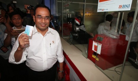 Menteri Perhubungan Budi Karya Sumadi mengambil tiket KRL Jabodetabek saat melakukan peninjauan di Stasiun Juanda, Jakarta, Rabu (10/8).