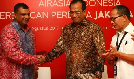 Menteri Perhubungan Budi Karya Sumadi (tengah) disaksikan Deputi Bidang Pengembangan Pemasaran Pariwisata Mancanegara Kementerian Pariwisata I Gde Pitana (kananan) memberi ucapan selamat kepada CEO Air Asia Tony Fernandez (kiri) atas pembukaan penerbangan baru Jakarta-Makau saat penyambutan pendaratan perdana dari Makau di Terminal 2 Bandara Soekarno Hatta, Tangerang, Banten, Senin (7/8).