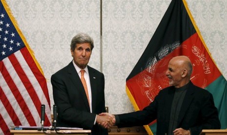 Menteri Luar Negeri AS John Kerry berjabat tangan dengan Presiden Afganistan Ashraf Gani dalam pertemuan di Kabul, Sabtu (9/4).