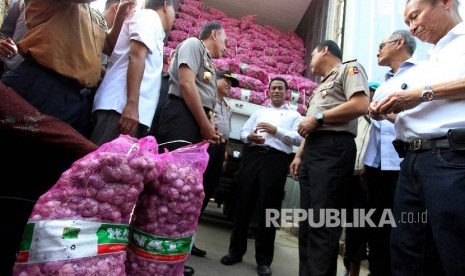 Menteri Pertanian Amran Sulaiman bersama dengan Kementerian Perdagangan dan Polri menyambut 2 kontainer bawang putih yang diimpor langsung dari China pada Operasi Pasar Bawang Putih di Pasar Induk Kramat Jati, Jakarta, Rabu (17/5).