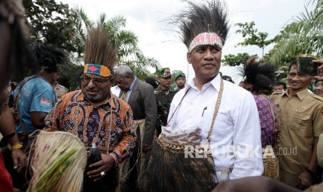 Menteri Pertanian Amran Sulaiman (kanan), bersama Gubernur Papua, Lukas Enembe (kiri) disambut oleh sejumlah warga saat mengujungi perbatasan Indonesia-Papua Nugini usai melakukan pelepasan ekspor perdana beras ke Papua Nugini, Papua, Senin (13/2). 