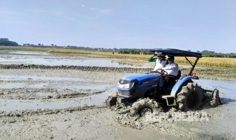 Menteri Pertanian Amran Sulaiman mencoba traktor milik petani di lokasi persawahan yang terletak di desa Samberan,  Kecamatan Kanor, Bojonegoro-Jawa Timur.