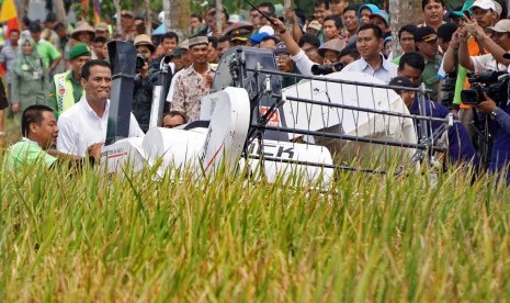 Menteri Pertanian Amran Sulaiman, mengemudikan mesin panen pada pada acara panen raya di Desa Mrenek, Maos, Cilacap, Jateng, Senin (29/2). (Antara/Idhad Zakaria)