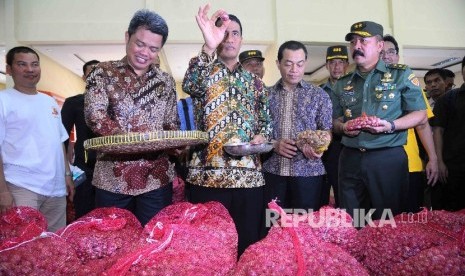 Menteri Pertanian, Amran Sulaiman (tengah) memeriksa bawang merah saat pembukaan Toko Tani Indonesia (TTI) di kawasan Pasar Minggu, Jakarta, Rabu (15/6). (Republika/ Agung Supriyanto)