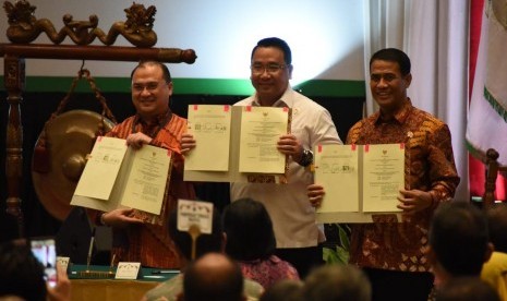 Menteri Pertanian Andi Amran Sulaiman (kanan) dan Kementerian Desa Pembangunan Daerah Tertingal dan Transmigrasi Eko Putro Sandjojo (tengah) menunjukkan piagam kerja sama