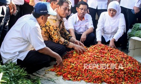 Menteri Pertanian Andi Amran Sulaiman (kedua kiri) Gubernur Jatim Khofifah Indar Parawansa (kanan) meninjau pedagang cabai saat operasi pasar murah bawang putih, di pasar baru Porong, Sidoarjo, Jawa Timur, Rabu (22/5/2019).