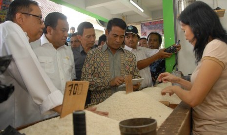 Menteri Pertanian, Andi Amran Sulaiman (tengah) bersama menteri Koperasi dan UKM AAGN Puspayoga (kiri) dan Menteri Perdagangan Rachmat Gobel (2 kiri) berbincang dengan pedagang beras saat inspeksi mendadak (sidak) di Pasar Cibinong, Kabupaten Bogor, Jabar,