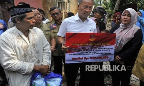 Menteri Sosial Agus Gumiwang Kartasasmita (tengah) secara simbolis menyerahkan bantuan kapada Bupati Pandeglang Irna Narulita (kanan) untuk warga korban gempa Banten di Kampung Panjang Jaya, Mandalawangi, Pandeglang, Banten, Sabtu (3/8/2019). 