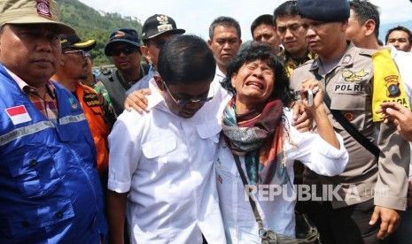 Menteri Sosial Idrus Marham (kedua kiri) memeluk Nuryati, keluarga penumpang KM Sinar Bangun saat meninjau lokasi tenggelamnya kapal, di Simalungun, Sumatera Utara, Ahad (24/6).