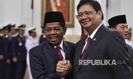 Menteri Sosial Idrus Marham (kiri) berjabat tangan dengan Ketua Umum Partai Golongan Karya sekaligus Menteri Perindustrian Airlangga Hartarto (kanan) usai pelantikan di Istana Negara, Jakarta, Rabu (17/1). 