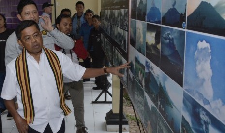 Menteri Sosial Idrus Marham (kiri) mengamati foto erupsi Gunung Agung saat melakukan kunjungan ke Pos Pemantauan Gunungapi Agung, Rendang, Karangasem, Bali, Sabtu (7/7). 