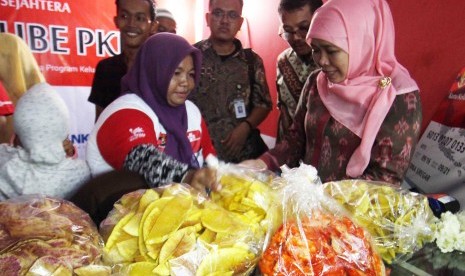 Menteri Sosial Khofifah Indar Parawansa (kanan) membeli produk makanan milik warga saat meluncurkan program Elektronik Warung Gotong Royong Kelompok Usaha Bersama Program Keluarga Harapan (E-Warong KUBE PKH) di Medan, Sumatera Utara, Jumat (14/10). 