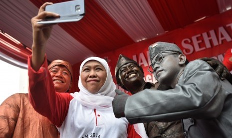 Menteri Sosial Khofifah Indar Parawansa (kedua kiri) berswafoto dengan sejumlah manusia patung karakter pahlawan ketika menghadiri jalan sehat dan doa lintas agama untuk pahlawan bangsa di kawasan Bundaran HI Jakarta, Minggu (6/11).