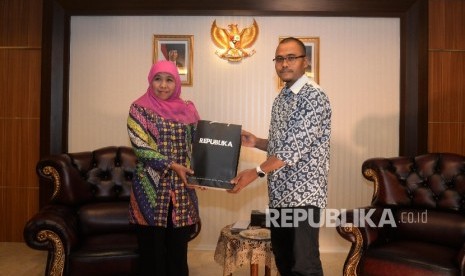 Menteri Sosial Khofifah Indar Parawansa (kiri) menerima cendera mata dari Pimred Harian Republika Irfan Junaidi saat berkunjung ke Kementerian Sosial RI, Jakarta, Jumat (23/12).