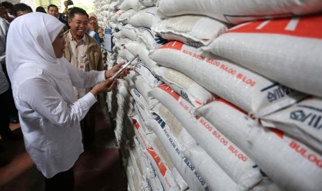 Menteri Sosial Khofifah Indar Parawansa (kiri) mengecek persedian beras untuk memenuhi kebutuhan logistik pengungsi korban bencana gempa Pidie Jaya di Gudang Bulog, Aceh Besar, Aceh, Jumat (9/12).