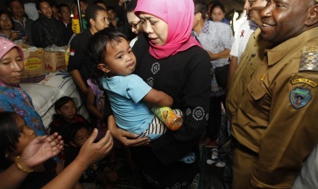 Menteri Sosial Khofifah Indar Parawansa mengendong balita di tenda pengungsian korban peristiwa penyerangan sekelompok massa beberapa waktu yang lalu di Distrik Karubaka, Tolikara, Papua, Selasa (21/7).