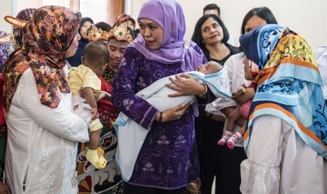 Menteri Sosial Khofifah Indar Parawansa (tengah) menggendong seorang anak saat menjenguk sejumlah anak korban eksploitasi di Rumah Perlindungan Sosial Anak (RPSA) Bambu Apus.