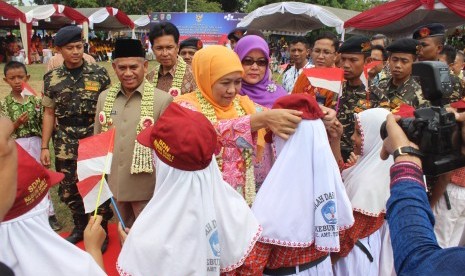 Menteri Sosial Khofifah Indar Parawansa (tengah) didampingi Regional CEO Bank Mandiri wilayah Kalimantan Anton Zulkarnain (keempat kiri), menyerahkan bantuan peralatan sekolah kepada siswa SD di Amuntai, Kalimantan Selatan, Kamis (27/7).  Selain bantuan kepada siswa, Bank Mandiri menyalurkan bantuan sosial Program Keluarga Harapan (PKH) sebesar Rp 9,019 miliar kepada 4.772 keluarga penerima manfaat di Kabupaten Hulu Sungai Utara, Kalimantan Selatan.