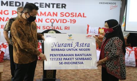 Menteri Sosial Republik Indonesia Juliari P. Batubara (kiri) menyimak sambutan Head of Environment and Social Responsibility Astra Diah Suran Febrianti (kanan) pada acara penyerahan bantuan paket sembako di Kementerian Sosial RI, Jakarta (8/5).