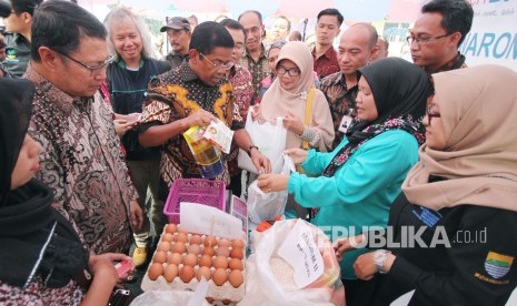 Menteri Sosial RI Idrus Marham berbincang dengan warga penerima bantuan yang sedang berbelanja sembako usai penyerahan bantuan Penyaluran Bantuan Sosial Program Keluarga harapan (PKH) dan Bantuan Pangan Non Tunai (BPNT), di Aula Wyata Guna, Kota Bandung, Kamis (1/3).