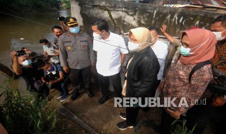 Menteri Sosial Tri Rismaharini (kedua kanan) didampingi Wakil Gubernur Sulut Steven Kandouw (ketiga kanan) meninjau permukiman terdampak banjir di Kelurahan Ternate Tanjung, Manado, Sulawesi Utara, Rabu (20/1/2021). Selain meninjau secara langsung kondisi permukiman dan pengungsian warga, Menteri Sosial juga menyerahkan bantuan sembako, perkakas dapur, selimut, kebutuhan balita kepada warga di lokasi terdampak banjir. 