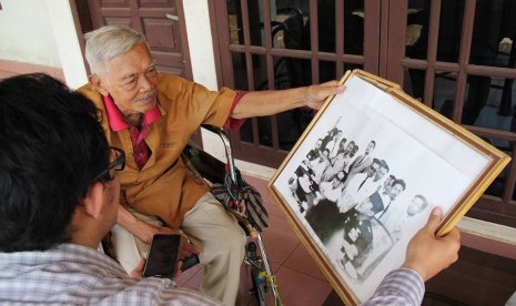 Menteri Transmigrasi dan Koperasi Kabinet Dwikora M. Achadi sedang menunjukkan foto rapat kabinet bersama Presiden Sukarno di Istana Bogor setelah peristiwa G30S..