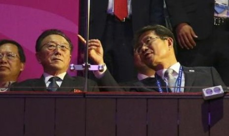 Menteri Unifikasi Korea Selatan Ryoo Kihl-Jae (kanan) berbincang dengan Kim Yang Gon, direktur Partai Buruh Korea Utara, saat penutupan Asian Games ke-17 di Incheon.