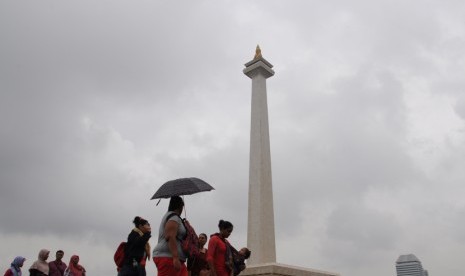   Meski hujan, banyak warga yang mengisi waktu libur dengan berwisata ke kawasan Monumen Nasional (Monas), Jakarta, Kamis (19/2).  (foto : MgROL_34)