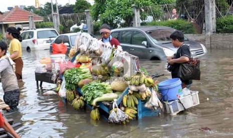  Meski masih tergenang air banjir,pedagang sayur keliling tetap berjualan melayani warga Apartemen Laguna Pluit di kawasan mewah Pluit, Penjaringan, Jakarta Utara, Ahad (20/1). (Republika/Rakhmawaty La'lang)