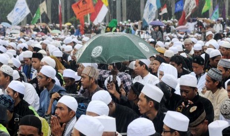  Meskipun diguyur hujan, ribuan umat Islam dengan khidmat mengikuti peringatan Maulid Nabi Muhammad SAW Majelis Rasulullah di kawasan Silang Monas, Jakarta Pusat, Kamis (24/1).   (Republika/Aditya Pradana Putra )