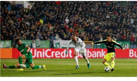 Mesut Oezil (kanan) saat mengecoh kiper dan dua pemain bertahan Ludogorets sebelum mencetak gol kemenangan Arsenal.